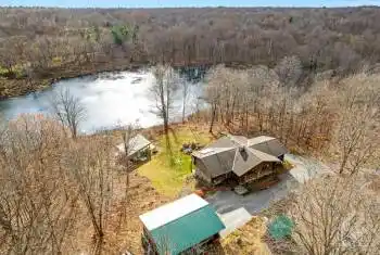 Peacefully private 26 acres with scribed log home, detached garage and lake-pond