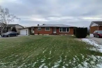 Ranch-style home featuring a front lawn and a garage