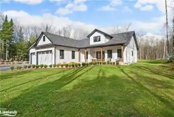 Modern farmhouse style home featuring a front lawn, a garage, and covered porch