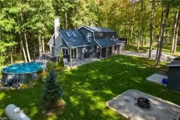 Rear view of property featuring a lawn, a fire pit, and a patio area
