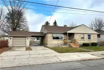 View of front of home with a garage and a carport
