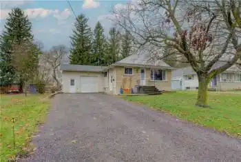 Single story home featuring a front yard and a garage